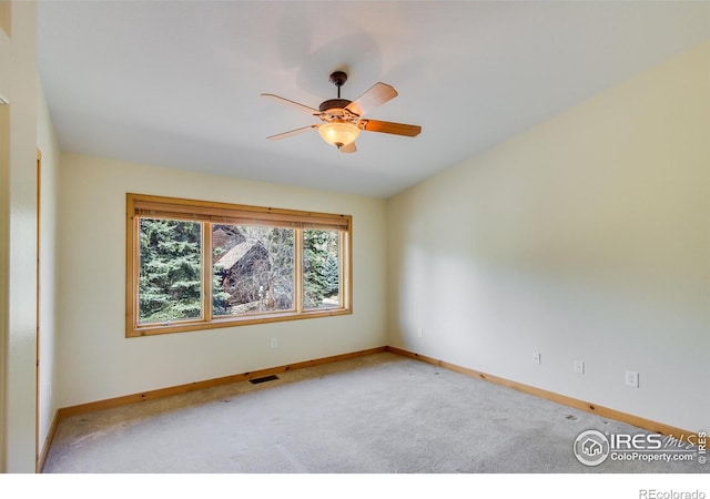 carpeted spare room with ceiling fan