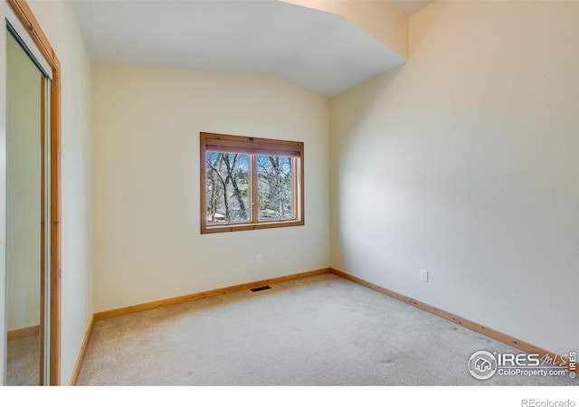 spare room with carpet and lofted ceiling