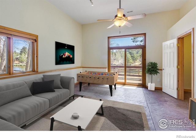 living room with vaulted ceiling, ceiling fan, and a healthy amount of sunlight