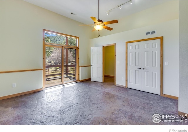 unfurnished bedroom with a closet, access to outside, track lighting, and ceiling fan