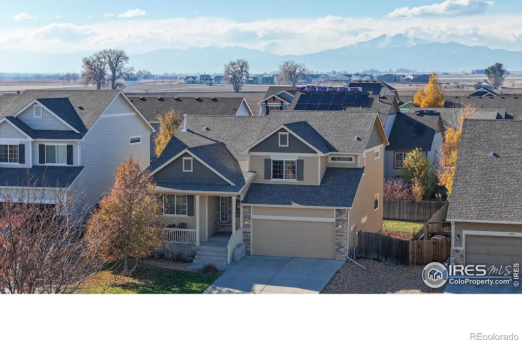 view of front of house featuring a mountain view, solar panels, and a garage