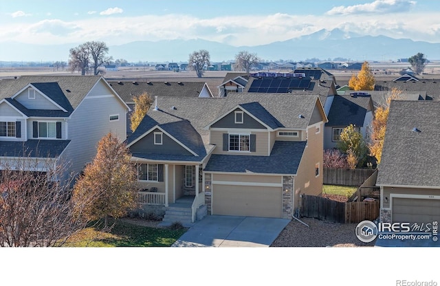 view of front of house featuring a mountain view, solar panels, and a garage