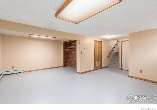 finished basement featuring visible vents, a textured ceiling, baseboards, and stairs