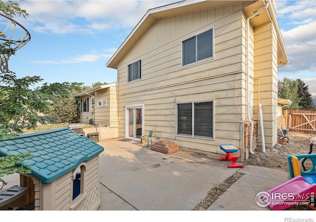 rear view of house with a patio area and fence