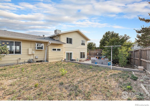 rear view of property with a lawn, a patio area, and a fenced backyard