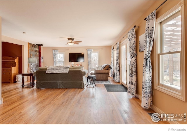 living room featuring ceiling fan, a healthy amount of sunlight, and light hardwood / wood-style flooring