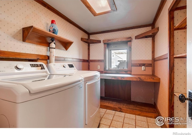 washroom featuring light wood-type flooring, washer and clothes dryer, and crown molding