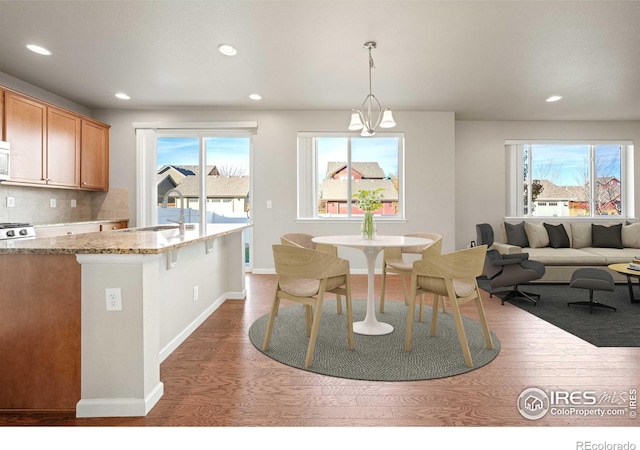 dining space featuring plenty of natural light, dark hardwood / wood-style floors, sink, and a chandelier