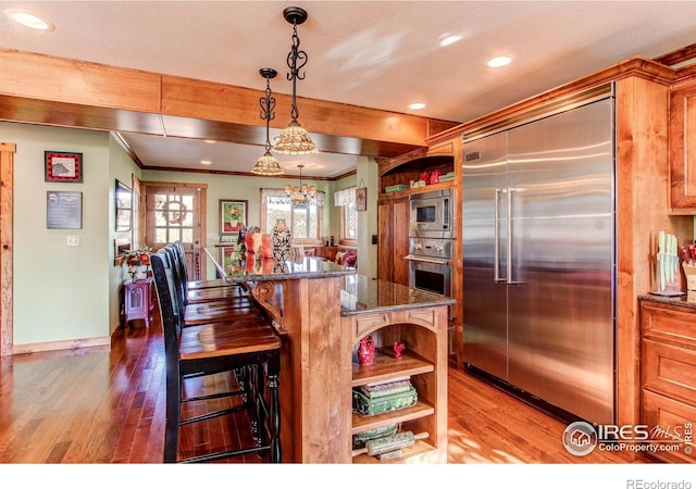 580 Saddle Notch Rd, Loveland, CO 80537 - kitchen with built in appliances, open shelves, hardwood / wood-style flooring, recessed lighting, and crown molding
