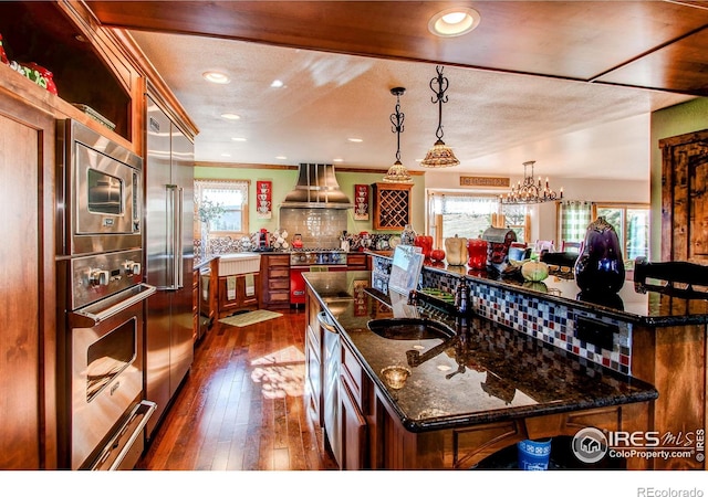 580 Saddle Notch Rd, Loveland, CO 80537 - kitchen featuring a large island, a sink, island exhaust hood, high quality appliances, and dark wood-type flooring