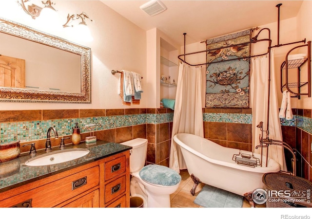 580 Saddle Notch Rd, Loveland, CO 80537 - bathroom featuring tile walls, a freestanding bath, toilet, vanity, and tile patterned floors