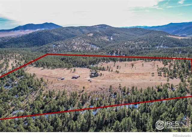 580 Saddle Notch Rd, Loveland, CO 80537 - aerial view of property and surrounding area featuring a mountainous background, property parcel outlined, and a forest