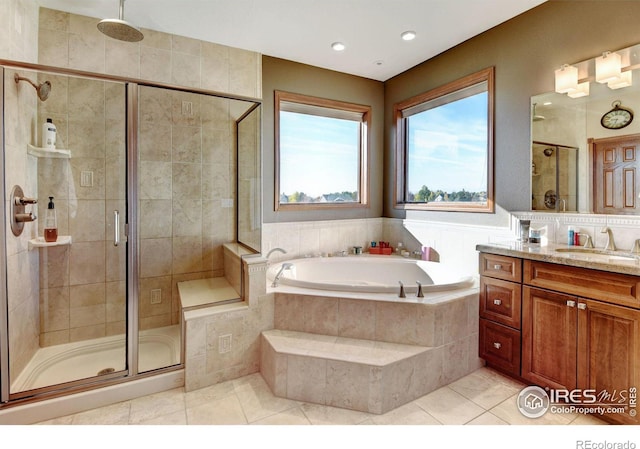 bathroom featuring tile patterned floors, vanity, and shower with separate bathtub