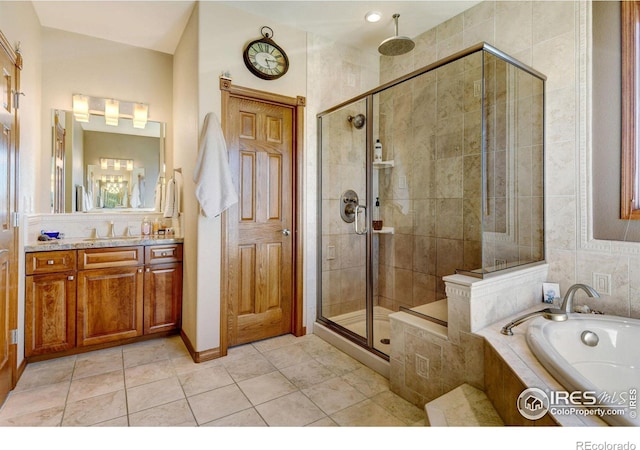 bathroom featuring plus walk in shower, vanity, and tile patterned flooring