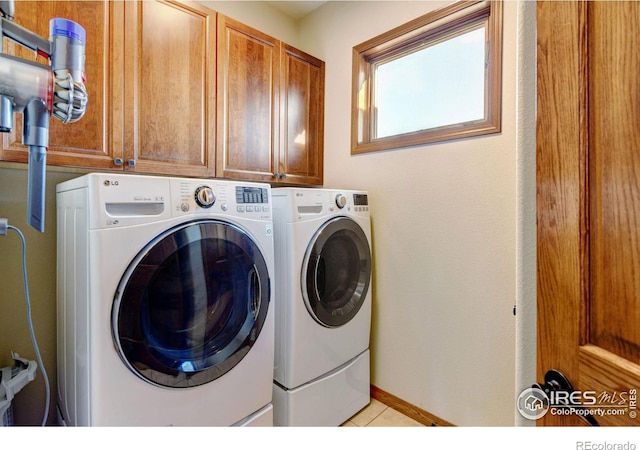 laundry area featuring washer and dryer and cabinets