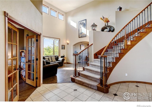 entryway with a high ceiling and light wood-type flooring