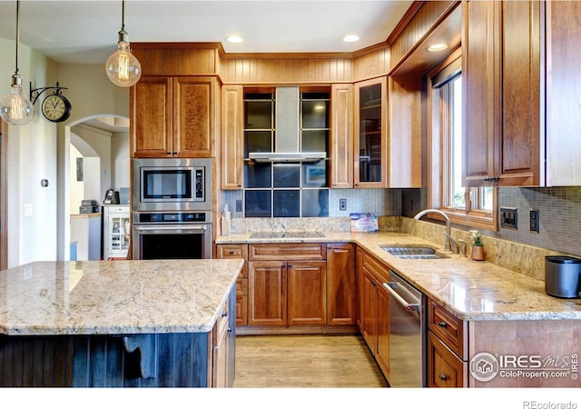 kitchen featuring sink, extractor fan, decorative light fixtures, decorative backsplash, and appliances with stainless steel finishes