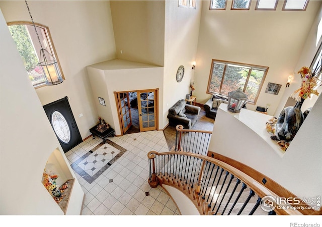 tiled foyer with a towering ceiling