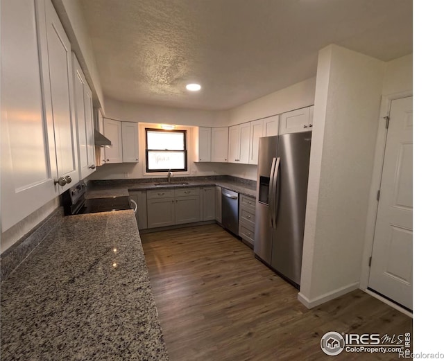 kitchen featuring sink, white cabinetry, dark hardwood / wood-style floors, stainless steel appliances, and exhaust hood