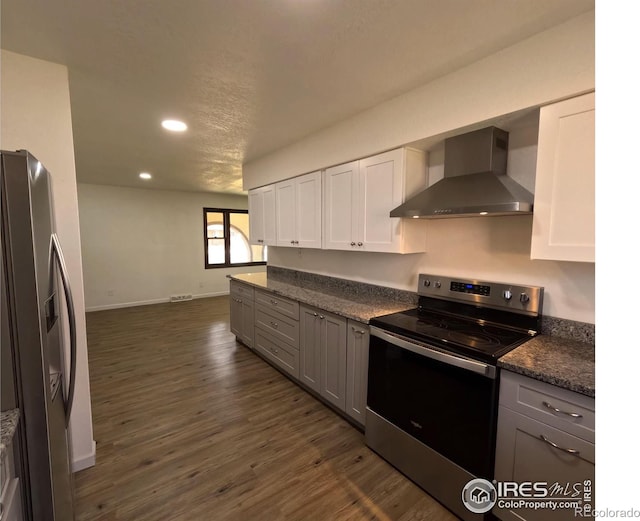 kitchen featuring stainless steel appliances, white cabinetry, dark hardwood / wood-style floors, and wall chimney exhaust hood