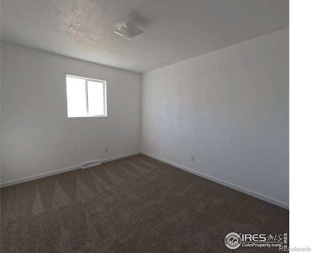 carpeted spare room with a textured ceiling