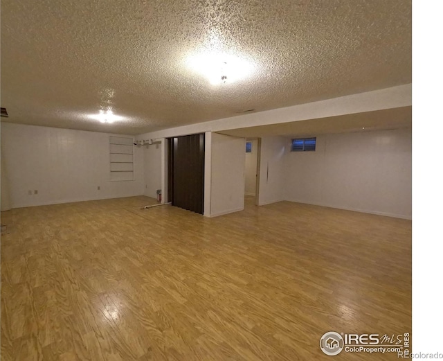 basement with wood-type flooring and a textured ceiling