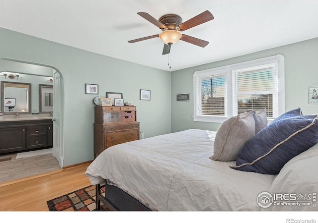 bedroom with ceiling fan, sink, ensuite bathroom, and light wood-type flooring