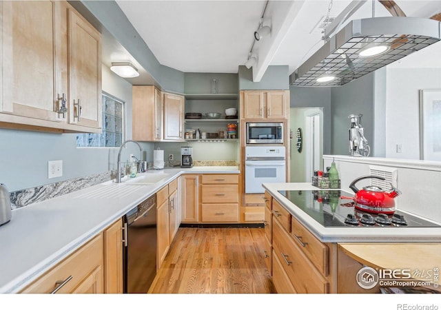 kitchen with sink, track lighting, light brown cabinetry, black appliances, and light wood-type flooring