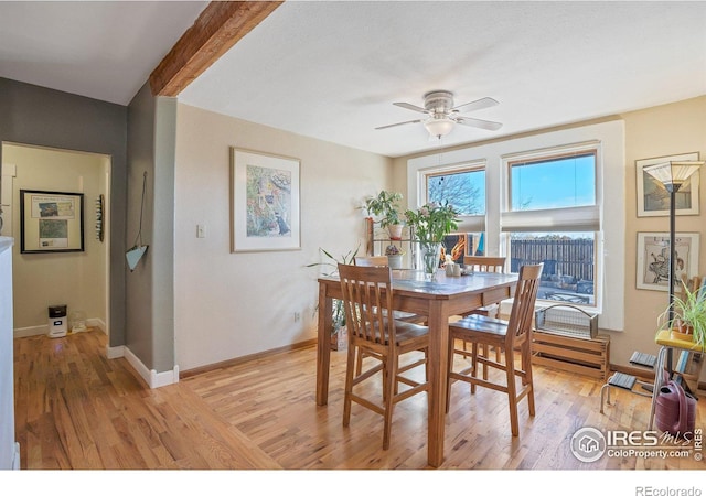 dining space with beam ceiling, light hardwood / wood-style flooring, and ceiling fan