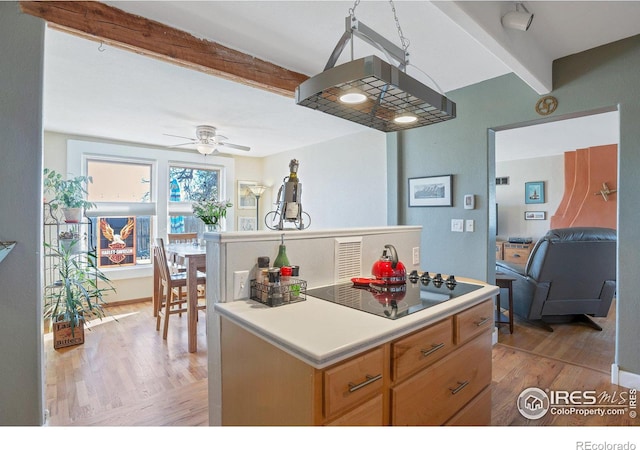 2981 W 144th Ave, Broomfield, CO 80023 - kitchen with beamed ceiling, black electric cooktop, light wood-type flooring, ceiling fan, and a kitchen island