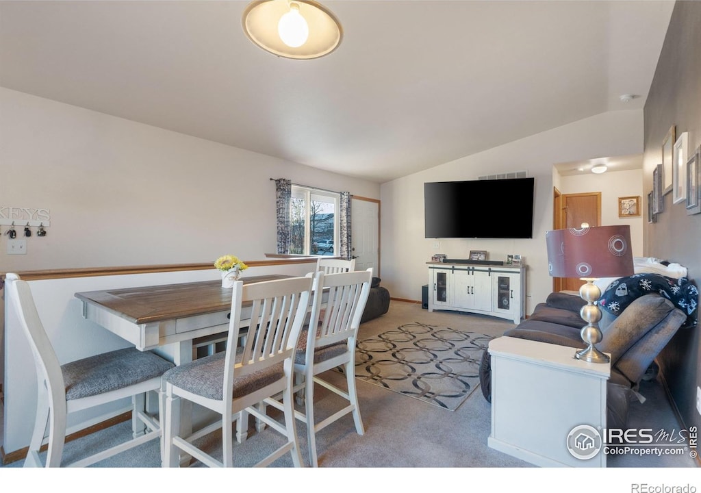 carpeted living room with vaulted ceiling