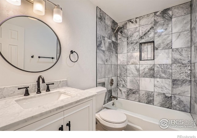 full bathroom featuring vanity, tiled shower / bath combo, and toilet