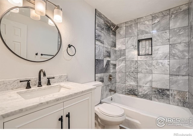 full bathroom featuring vanity, toilet, and tiled shower / bath