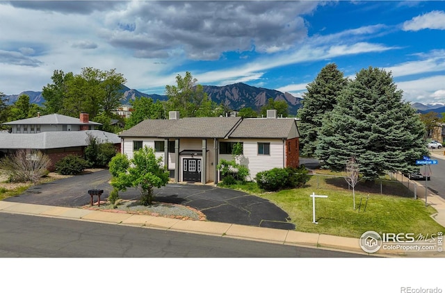 view of front of property with a mountain view and a front lawn