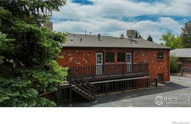 rear view of house with central air condition unit and a wooden deck