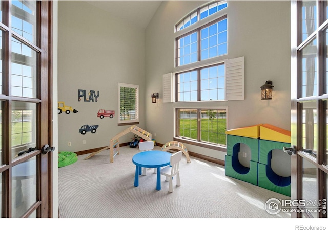 game room featuring carpet, french doors, and a high ceiling