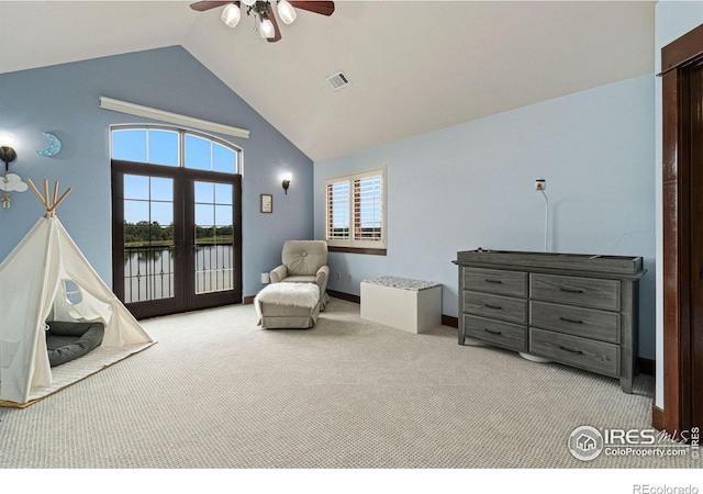 living area featuring ceiling fan, french doors, high vaulted ceiling, light colored carpet, and a water view