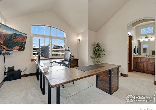 carpeted home office featuring vaulted ceiling