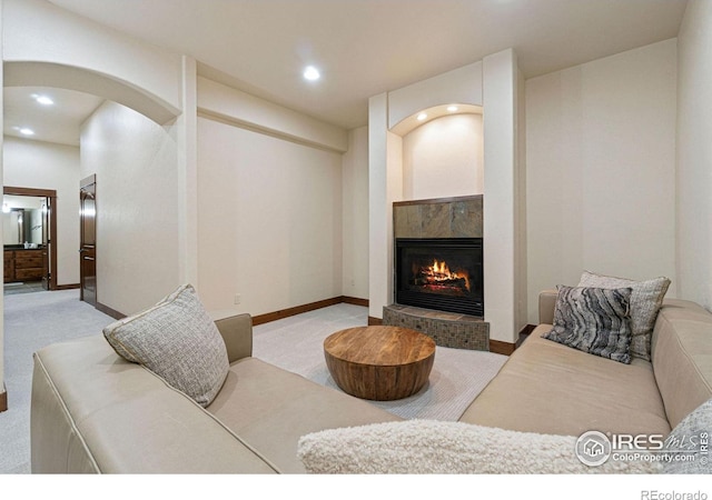 living room featuring a premium fireplace and light colored carpet