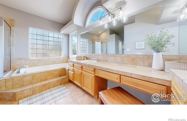 bathroom with tile patterned flooring, shower with separate bathtub, and vanity