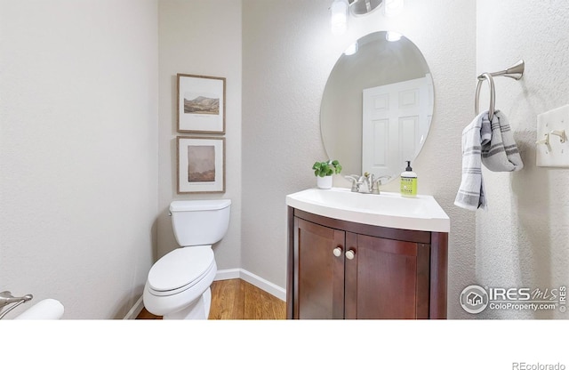 bathroom featuring hardwood / wood-style flooring, vanity, and toilet