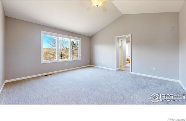 unfurnished room with light colored carpet, vaulted ceiling, and ceiling fan