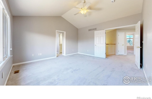 unfurnished bedroom with ceiling fan, light colored carpet, and vaulted ceiling