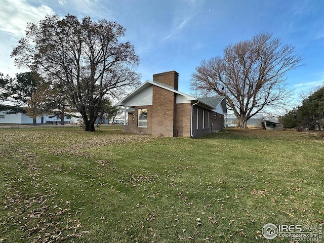 view of side of home with a yard