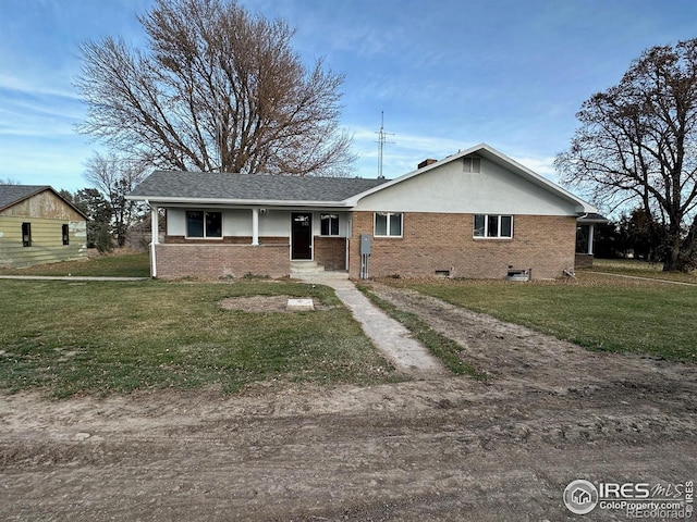 ranch-style house featuring driveway, brick siding, and a front yard