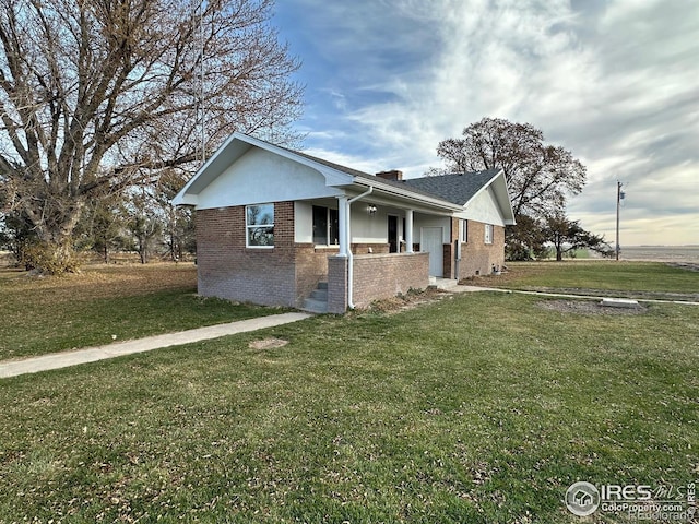 view of side of property with a yard and brick siding