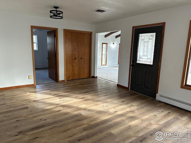 foyer entrance with baseboards, baseboard heating, and wood finished floors