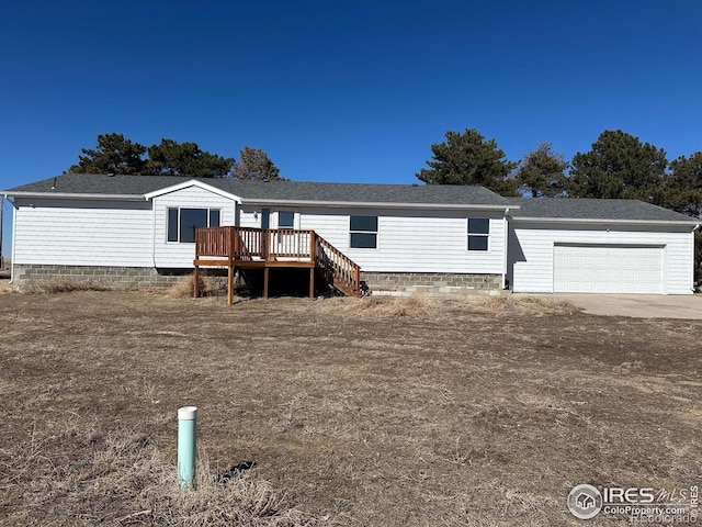 manufactured / mobile home featuring a deck, driveway, an attached garage, and stairs