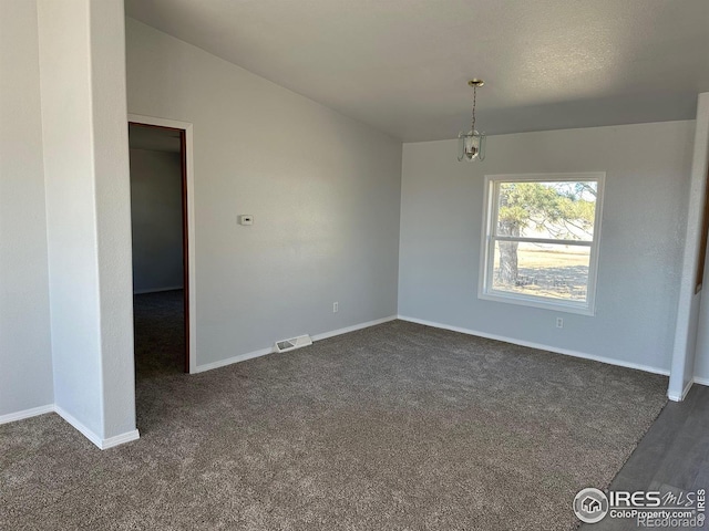 unfurnished room featuring dark colored carpet, visible vents, and baseboards