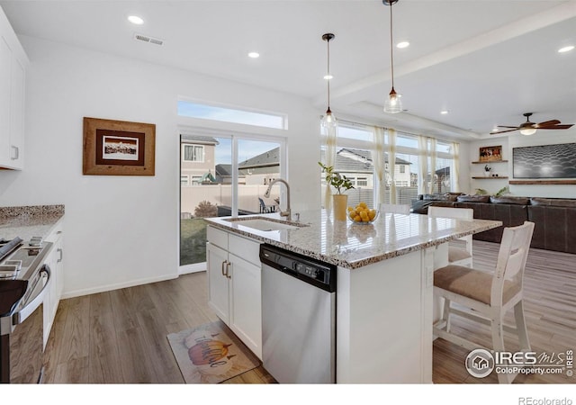 kitchen featuring white cabinets, an island with sink, stainless steel appliances, and sink